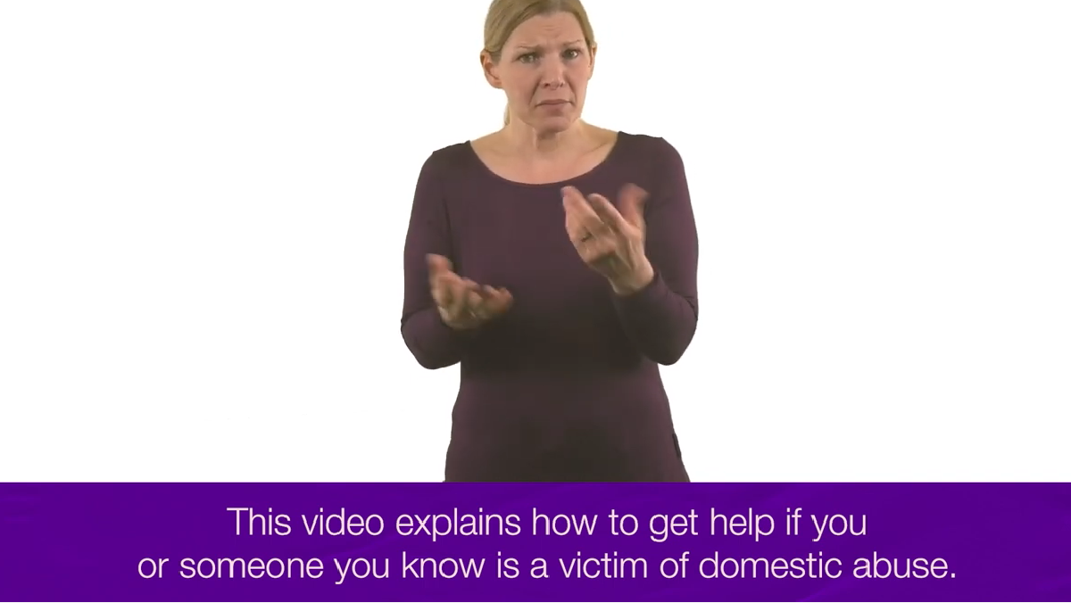 Screenshot from a BSL Video about domestic abuse. Picture of a woman signing with subtitles - "This video explains how to get help if you or someone you know is a victim of domestic abuse".