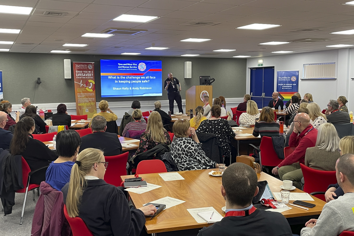 Attendees at Tyne and Wear Fire and Rescue Service Event on Preventing Fire Deaths. Picture of people sat listening to a presentation.